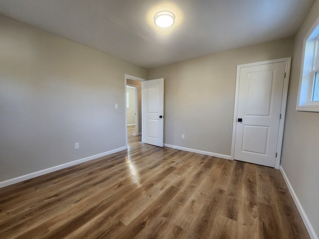 unfurnished bedroom with baseboards and wood finished floors