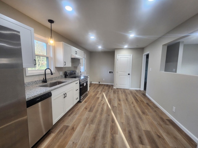 kitchen with sink, light stone counters, light hardwood / wood-style flooring, stainless steel appliances, and white cabinets