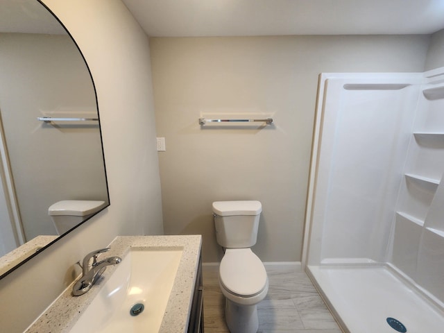 full bath featuring toilet, a shower stall, baseboards, and vanity