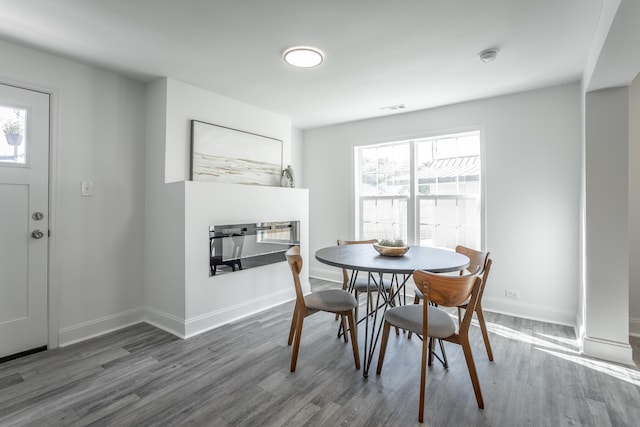 dining room featuring a healthy amount of sunlight and dark hardwood / wood-style floors