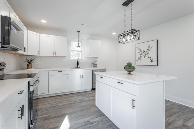 kitchen featuring sink, white cabinetry, a center island, hanging light fixtures, and appliances with stainless steel finishes