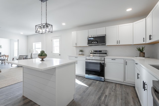 kitchen featuring hanging light fixtures, white cabinetry, appliances with stainless steel finishes, and decorative backsplash