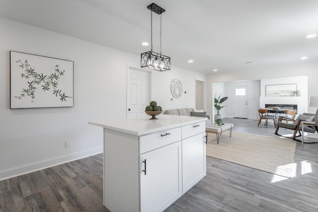 kitchen with white cabinetry, a center island, pendant lighting, and dark hardwood / wood-style floors