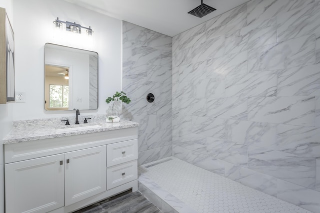 bathroom with vanity and a tile shower