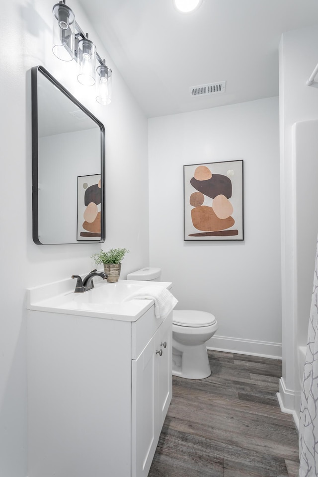 bathroom featuring vanity, hardwood / wood-style floors, and toilet