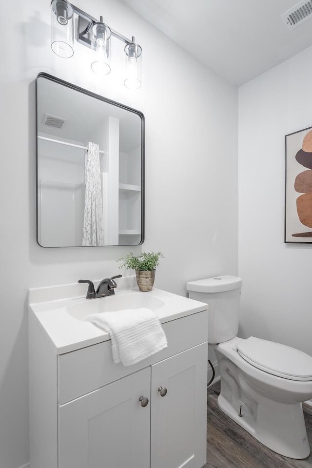 bathroom with vanity, hardwood / wood-style floors, and toilet