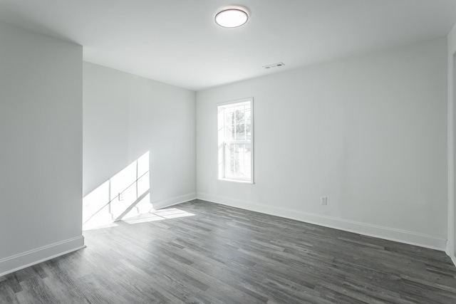 spare room with dark wood-type flooring