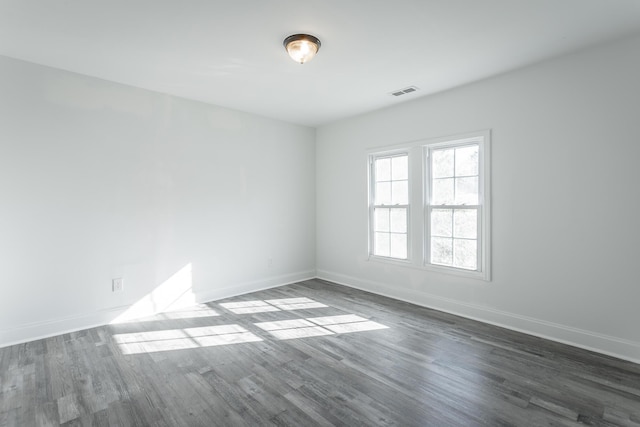 unfurnished room with dark wood-type flooring