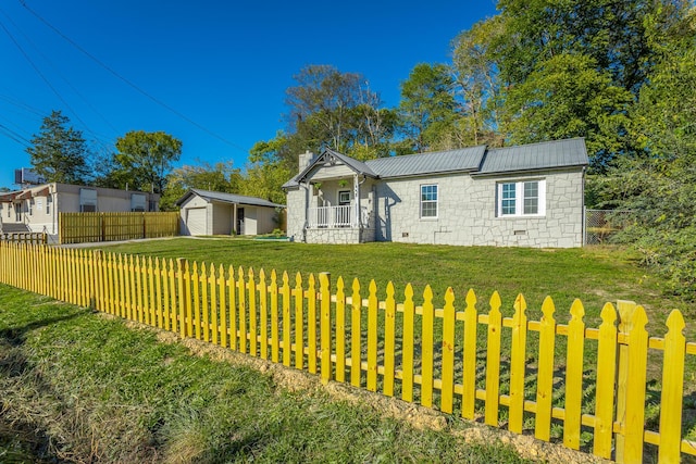 view of front of property with a garage, an outdoor structure, and a front lawn