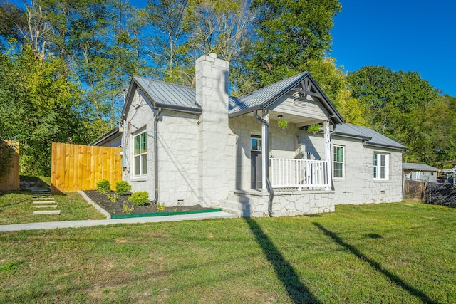 rear view of house with a yard and a porch