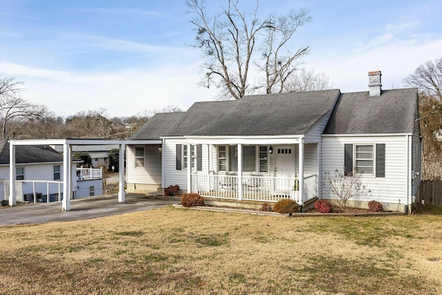 back of property with a carport, a porch, and a yard