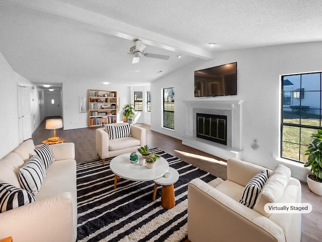 living room with vaulted ceiling with beams, plenty of natural light, a textured ceiling, and ceiling fan