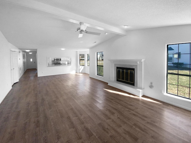 unfurnished living room featuring dark wood-type flooring, ceiling fan, lofted ceiling with beams, and a textured ceiling