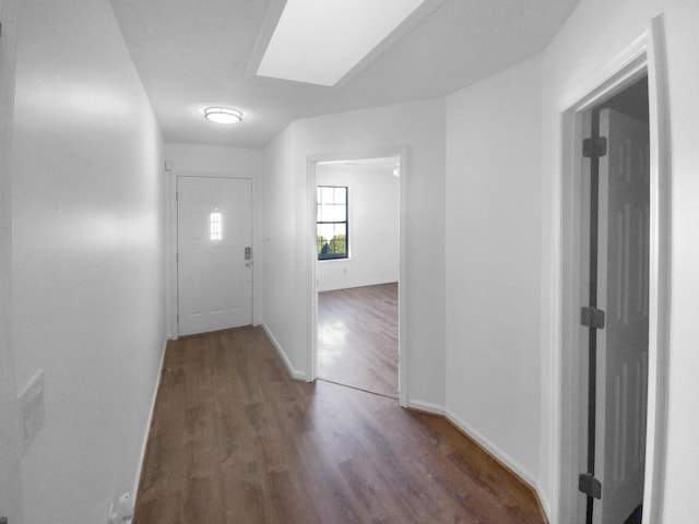 hall with dark hardwood / wood-style flooring and a skylight