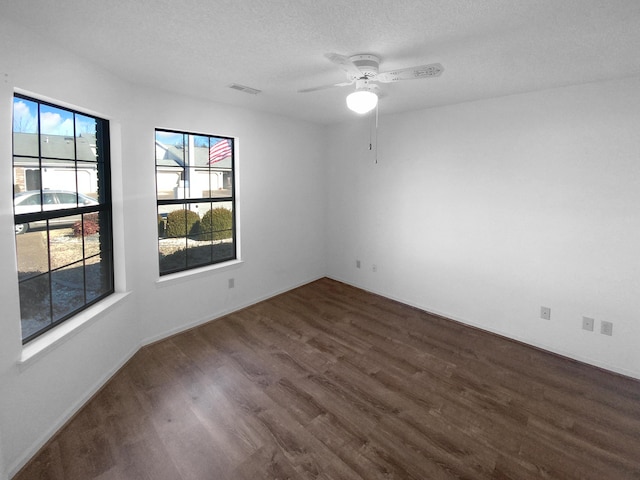 unfurnished room featuring ceiling fan, dark hardwood / wood-style floors, and a textured ceiling