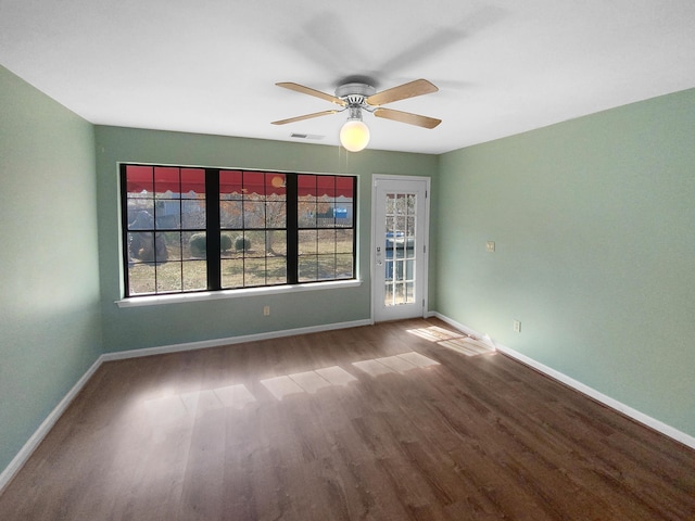 spare room with ceiling fan, wood-type flooring, and a wealth of natural light