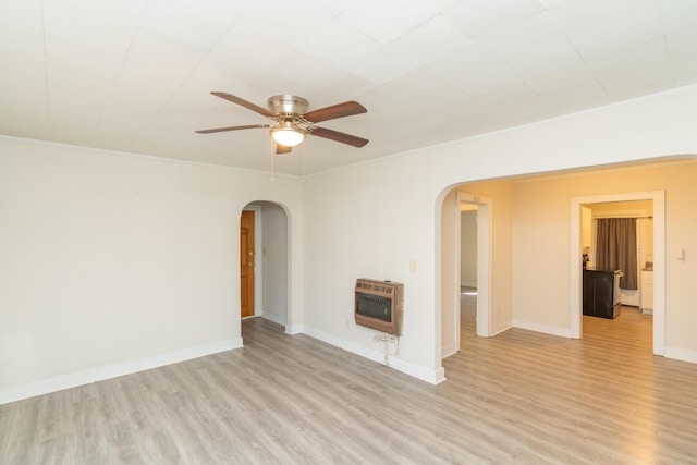 unfurnished living room with heating unit, light hardwood / wood-style flooring, ornamental molding, and ceiling fan