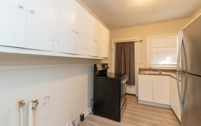 kitchen featuring stainless steel refrigerator, sink, white cabinets, electric range, and light hardwood / wood-style flooring