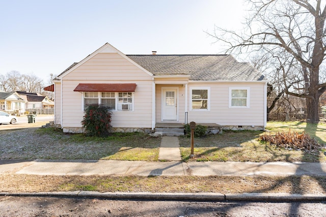 bungalow-style house with cooling unit and a front lawn