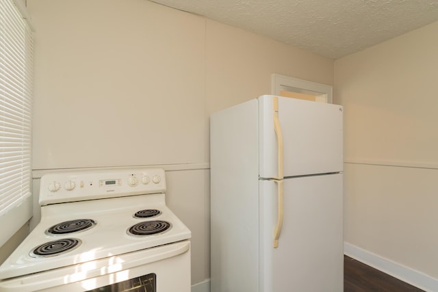 kitchen with dark hardwood / wood-style flooring, a textured ceiling, and white appliances