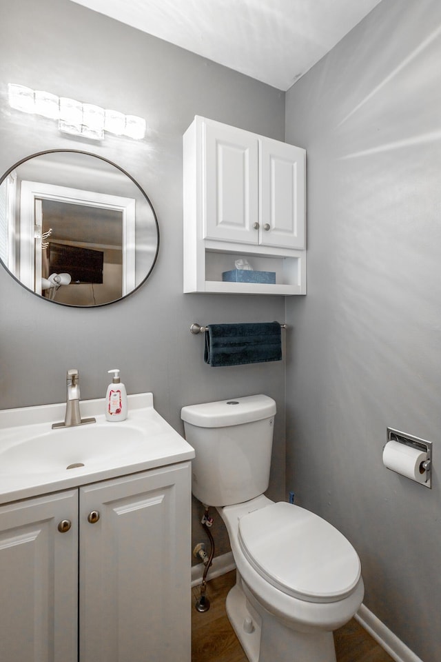 bathroom featuring vanity, wood-type flooring, and toilet