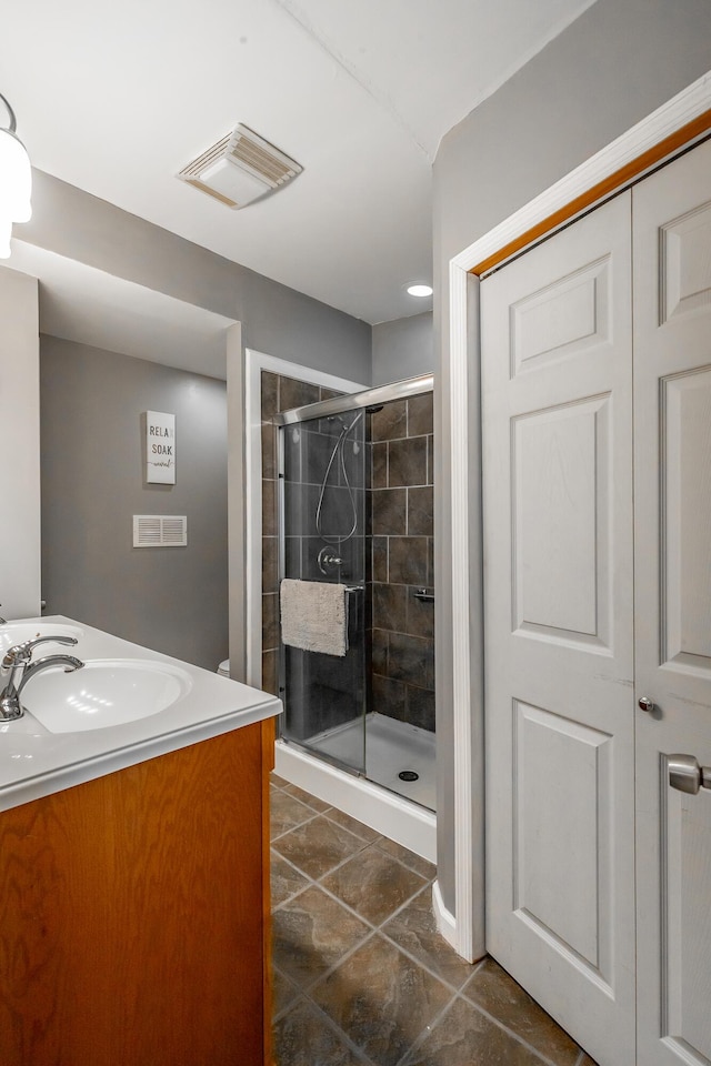 bathroom with vanity and a shower with shower door