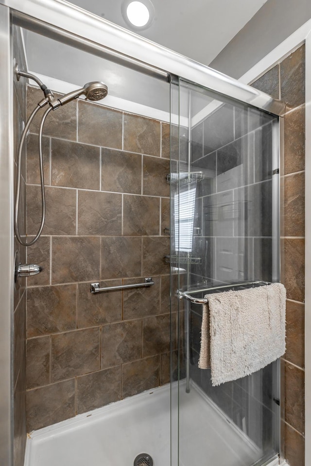 bathroom with a shower with door