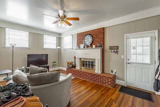 living room featuring ceiling fan, a fireplace, and dark hardwood / wood-style flooring