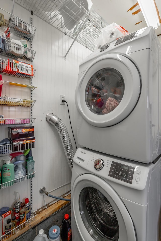 clothes washing area featuring stacked washer / dryer