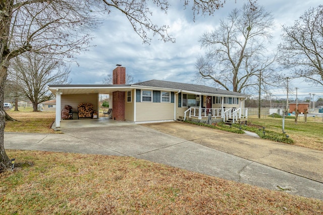 ranch-style home featuring a porch, a carport, and a front yard