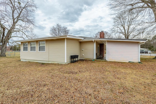 back of house featuring a lawn