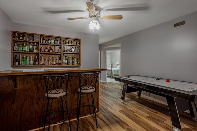 bar featuring ceiling fan and wood-type flooring