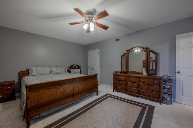 carpeted bedroom with ceiling fan and a closet