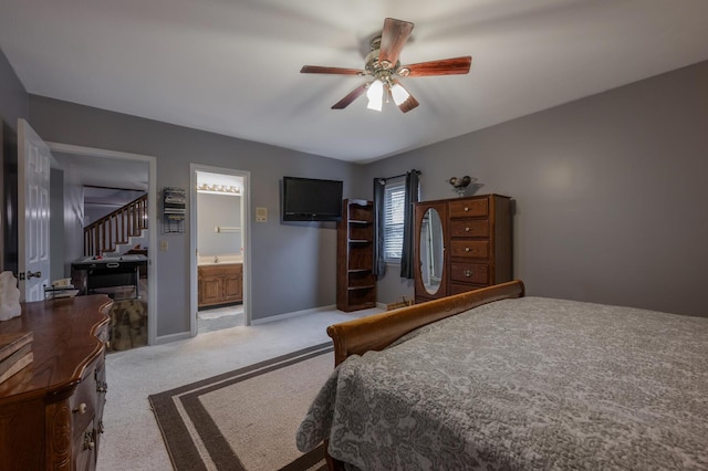 bedroom with ensuite bathroom, light colored carpet, and ceiling fan