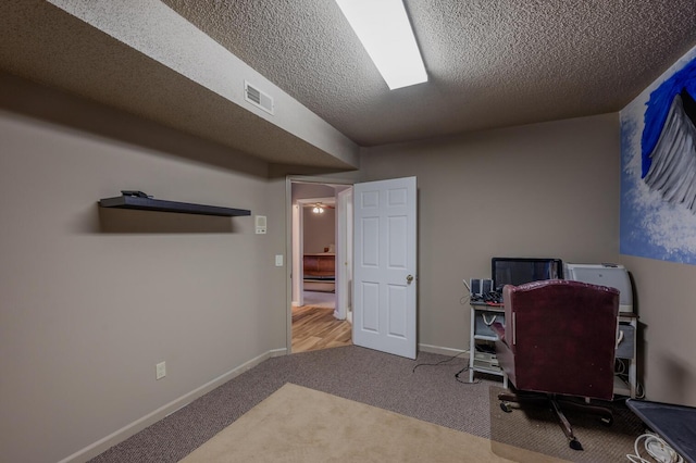 carpeted office with a textured ceiling