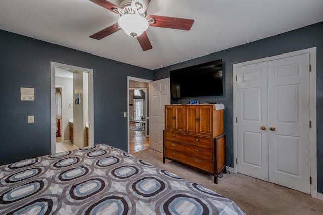 carpeted bedroom with ceiling fan, ensuite bath, and a closet