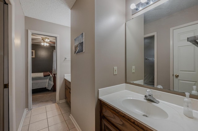 bathroom with ceiling fan, tile patterned floors, a textured ceiling, and vanity