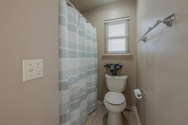 bathroom with a shower with curtain, a textured ceiling, tile patterned floors, and toilet