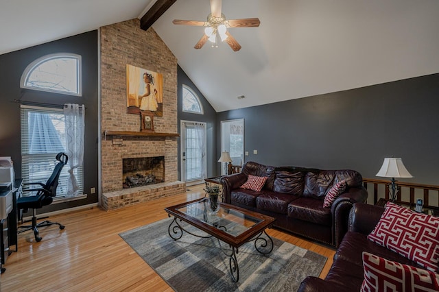 living room featuring a healthy amount of sunlight, hardwood / wood-style floors, high vaulted ceiling, and beamed ceiling