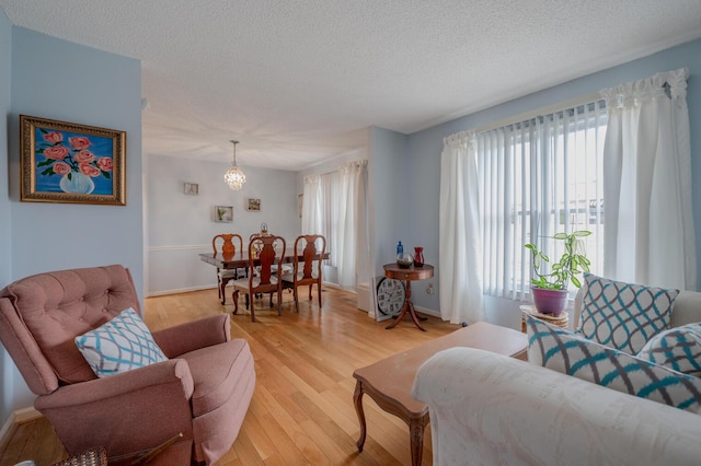 living room with a textured ceiling and light hardwood / wood-style floors