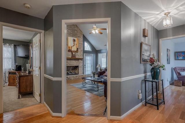 hall featuring lofted ceiling and light hardwood / wood-style flooring