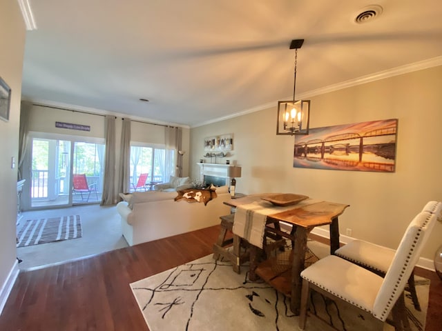 dining room featuring crown molding, wood-type flooring, and a notable chandelier