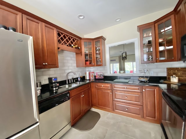 kitchen featuring appliances with stainless steel finishes, tasteful backsplash, sink, hanging light fixtures, and light tile patterned floors