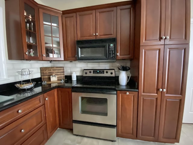 kitchen featuring stainless steel range with electric stovetop, dark stone counters, and decorative backsplash