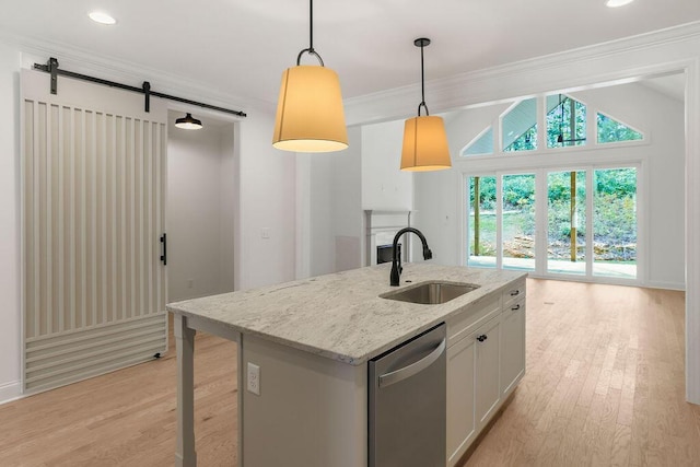 kitchen with sink, white cabinetry, hanging light fixtures, light stone countertops, and stainless steel dishwasher