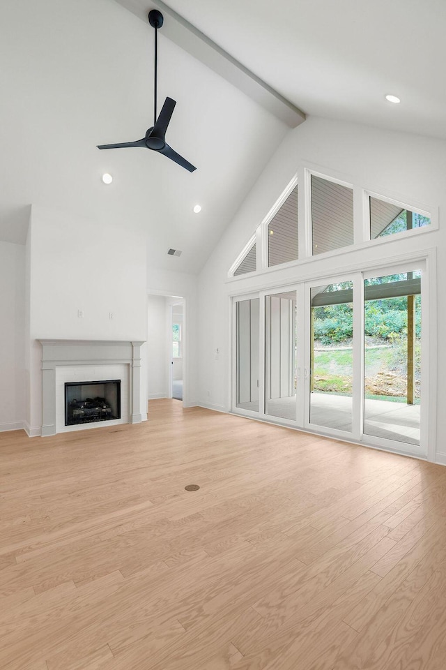 unfurnished living room with beamed ceiling, ceiling fan, high vaulted ceiling, and light hardwood / wood-style flooring