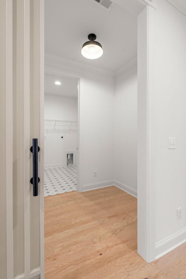 hallway featuring hardwood / wood-style flooring and ornamental molding