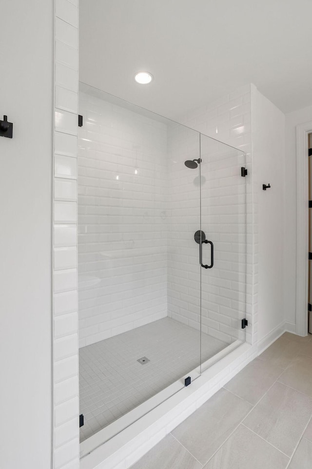 bathroom with tile patterned flooring and a shower with shower door