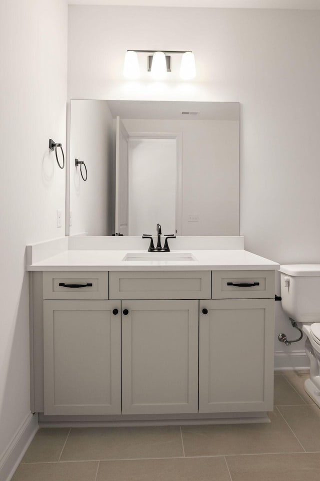 bathroom featuring tile patterned flooring, vanity, and toilet