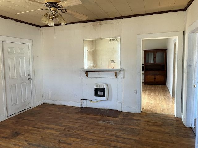 unfurnished living room featuring heating unit, crown molding, dark wood-type flooring, and ceiling fan